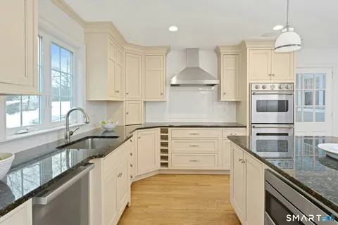 a kitchen with stainless steel appliances granite countertop a sink stove and cabinets