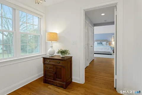 a hallway with view of wooden floor and cabinet