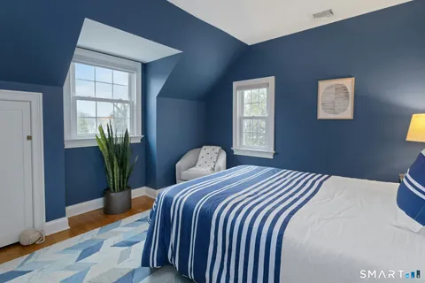 a bedroom with a bed and a potted plant