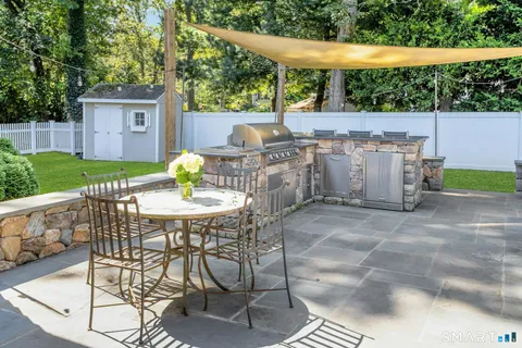 a view of a patio with table and chairs with wooden fence and plants