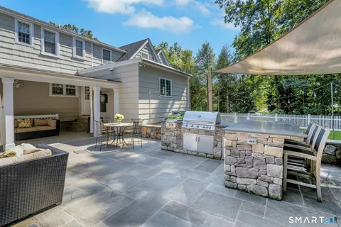 a view of a patio with a table and chairs under an umbrella
