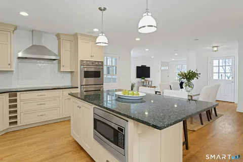 a kitchen with stainless steel appliances granite countertop a stove and a wooden floors