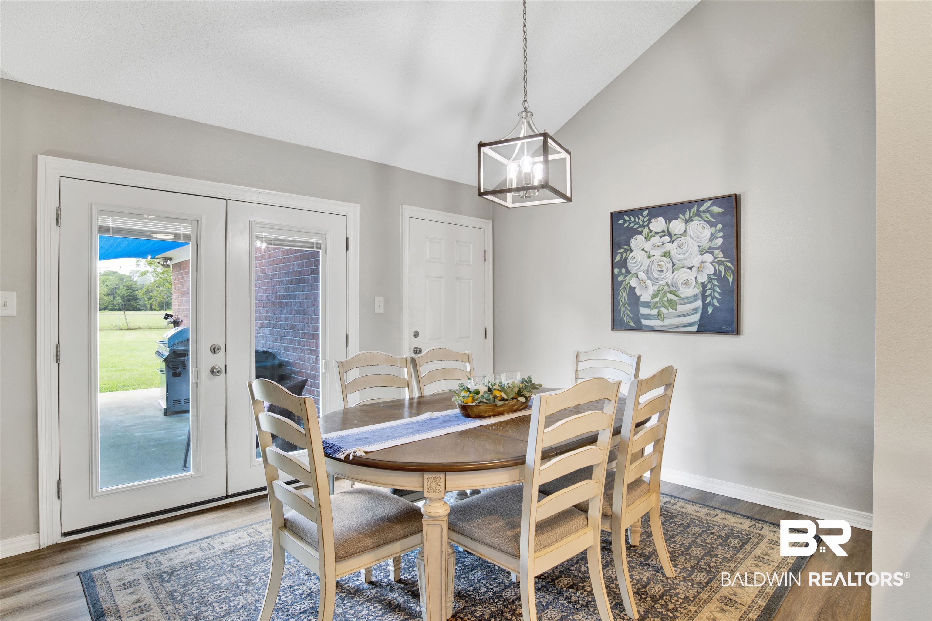 17483 East View Loop Foley, AL 36535 - Photo 13 of 30 Dining space featuring lofted ceiling, an inviting chandelier, dark hardwood / wood-style floors, and french doors