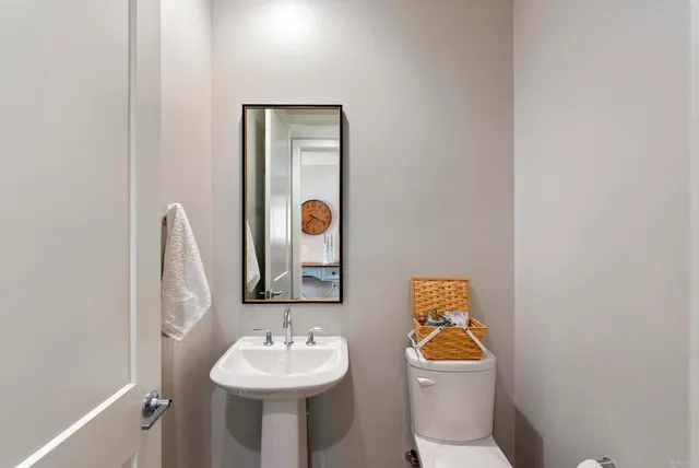 a bathroom with a toilet sink and mirror