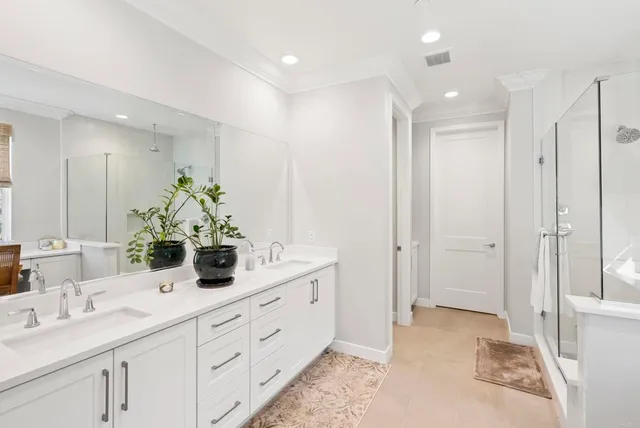 a bathroom with a double vanity sink mirror and next to a window