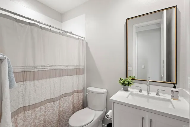 a bathroom with a sink vanity mirror and toilet