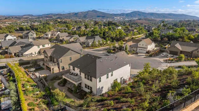 an aerial view of a house with a mountain