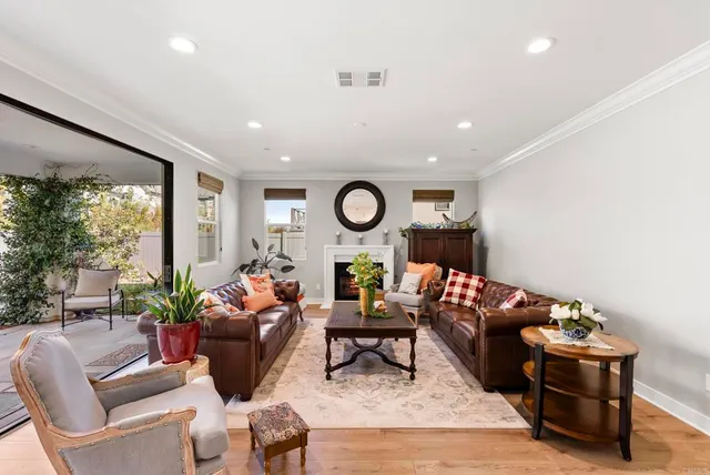 a living room with furniture a large window and a potted plant