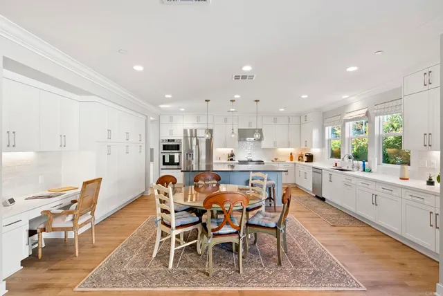 a dining area with stainless steel appliances kitchen island granite countertop a dining table and chairs