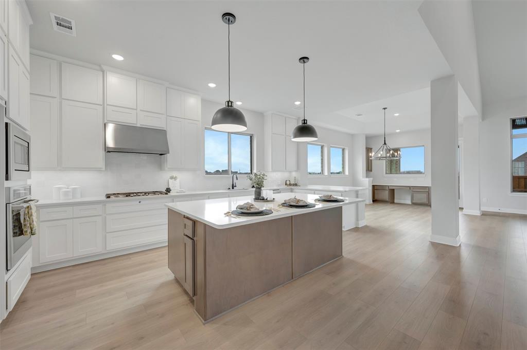 1103 Vista Way Rockwall, TX 75087 - Photo 22 of 26 a large kitchen with stainless steel appliances kitchen island granite countertop a sink a stove and a wooden floors