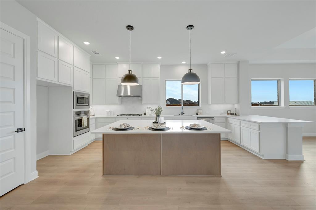1103 Vista Way Rockwall, TX 75087 - Photo 23 of 26 a kitchen with kitchen island a sink stainless steel appliances and cabinets