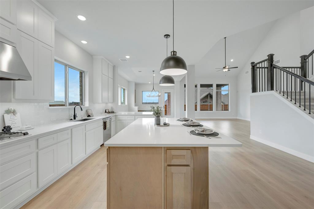 1103 Vista Way Rockwall, TX 75087 - Photo 25 of 26 a kitchen with stainless steel appliances granite countertop a sink a stove a refrigerator and white cabinets with wooden floor