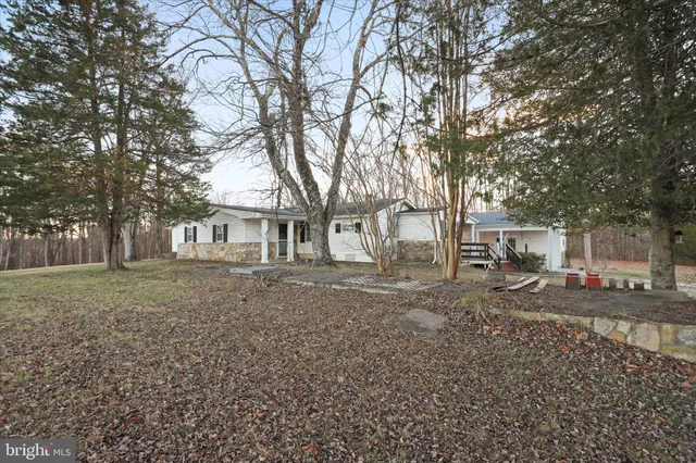 a view of house with a yard and sitting area