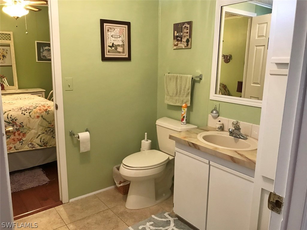 10441 Circle Pine Road North Fort Myers, FL 33903 - Photo 16 of 20 a bathroom with a toilet sink and mirror