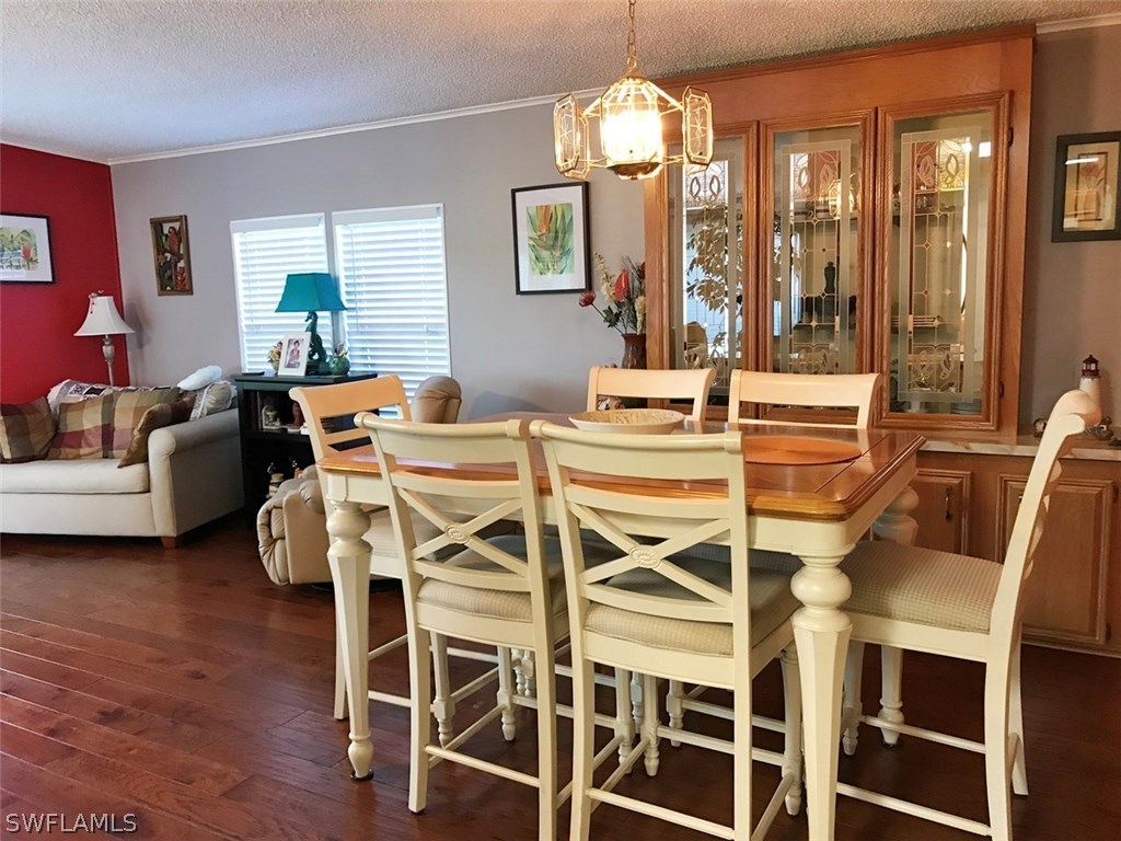 10441 Circle Pine Road North Fort Myers, FL 33903 - Photo 3 of 20 a view of a dining room with furniture wooden floor and chandelier