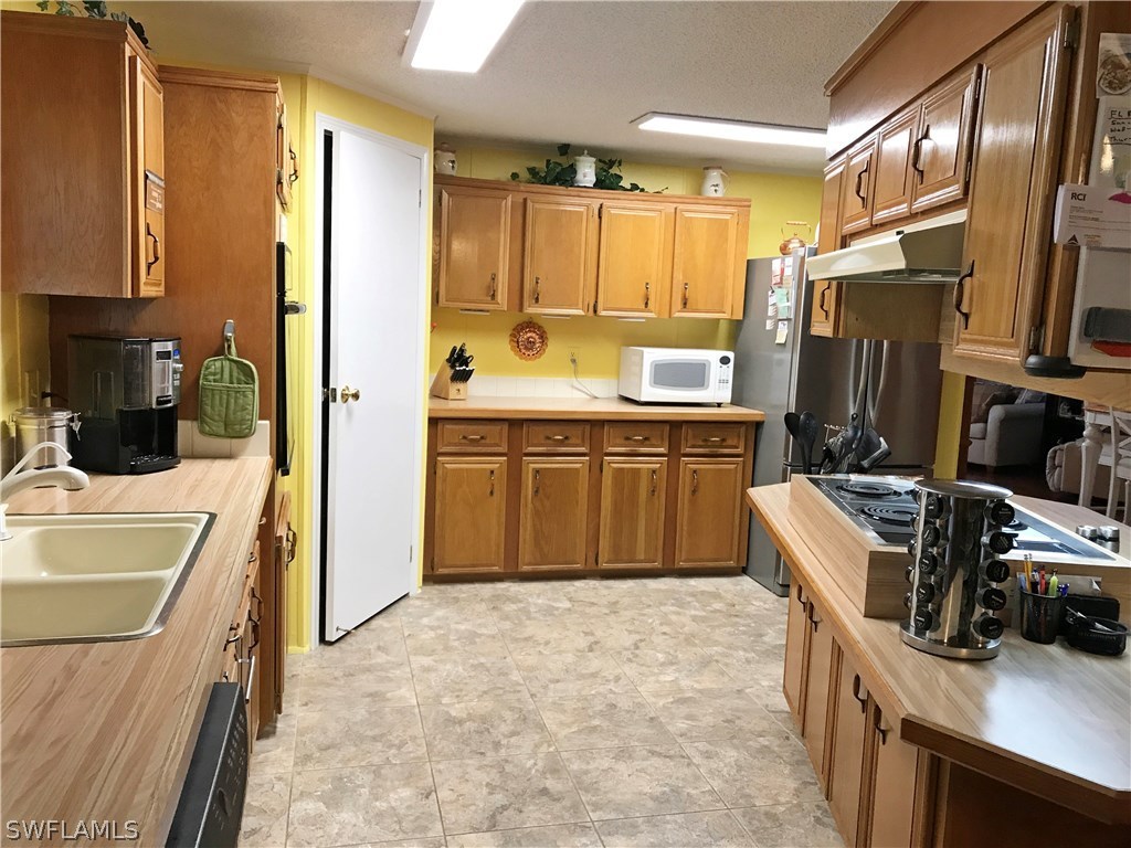 10441 Circle Pine Road North Fort Myers, FL 33903 - Photo 9 of 20 a kitchen with a sink stove and refrigerator