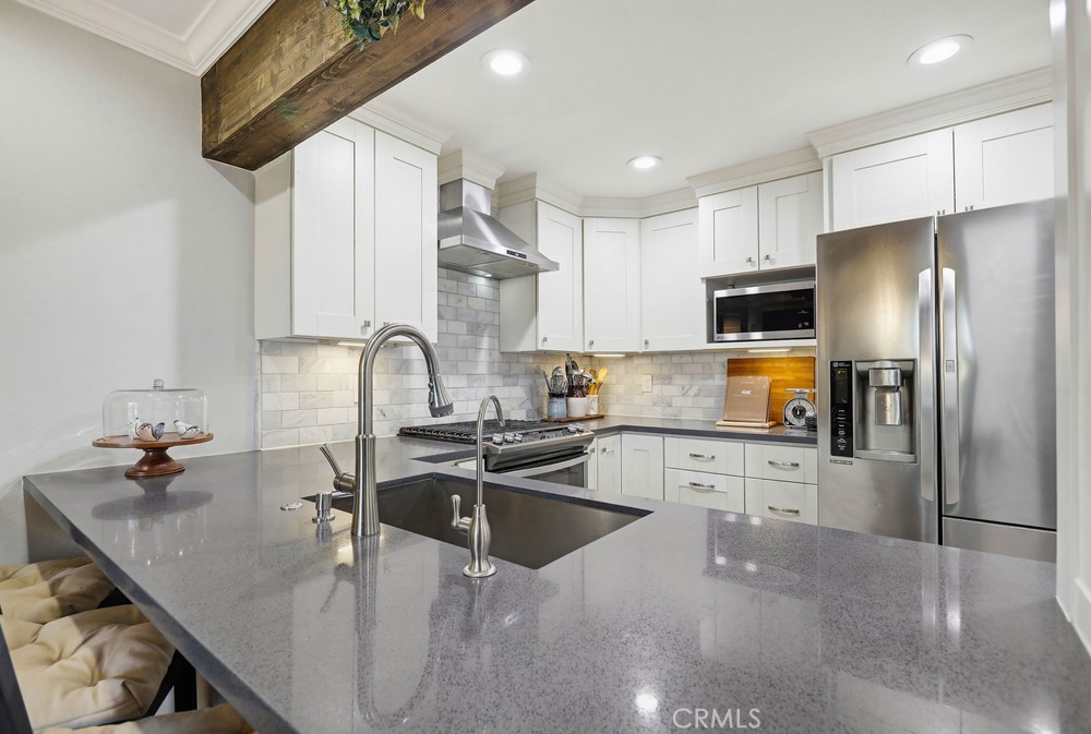47 Vía Lavendera Rancho Santa Margarita, CA 92688 - Photo 16 of 40 a kitchen with stainless steel appliances granite countertop a sink a stove and refrigerator