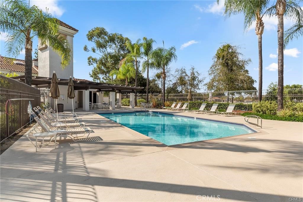 47 Vía Lavendera Rancho Santa Margarita, CA 92688 - Photo 36 of 40 a view of a swimming pool with a lawn chairs and palm tree