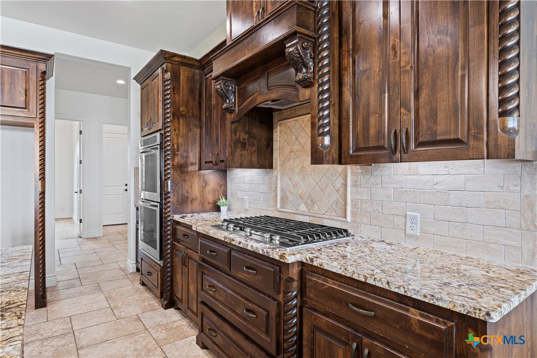 11023 Bigham Road Troy, TX 76579 - Photo 15 of 42 a kitchen with granite countertop a stove and cabinets