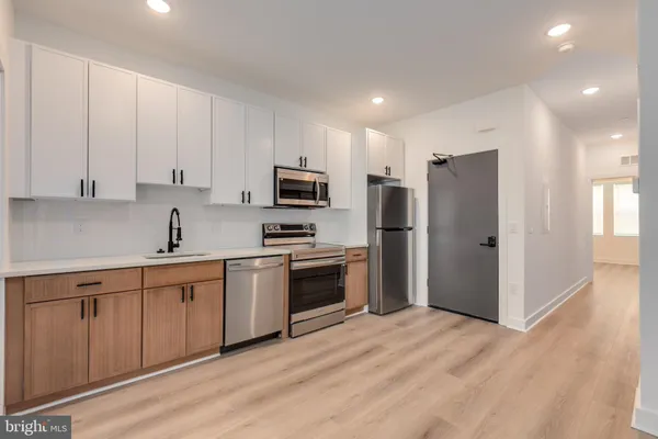 a kitchen with white cabinets and stainless steel appliances