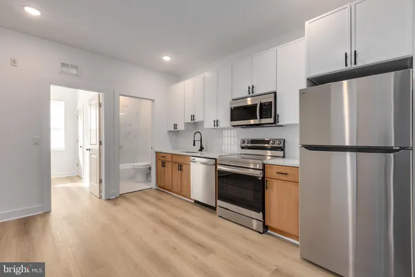 a kitchen with granite countertop a refrigerator stove and microwave