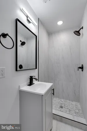 a bathroom with a sink a mirror a vanity and a shower