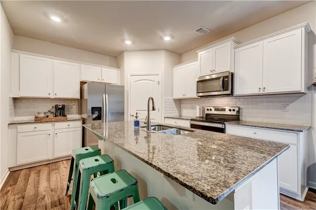 a kitchen with stainless steel appliances granite countertop a sink and a wooden cabinets