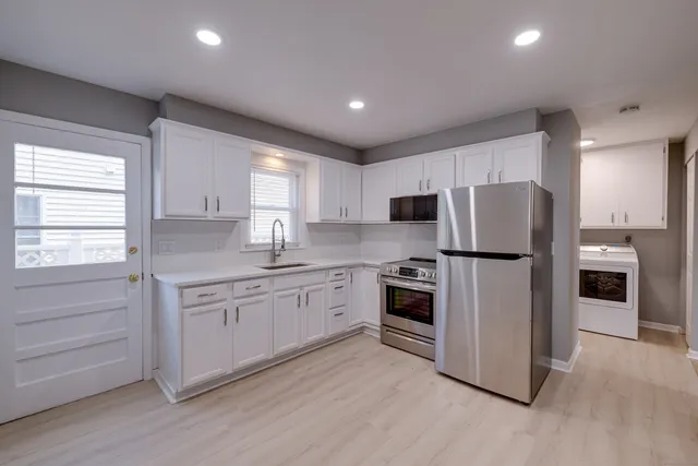 a kitchen with stainless steel appliances granite countertop a refrigerator and a stove top oven