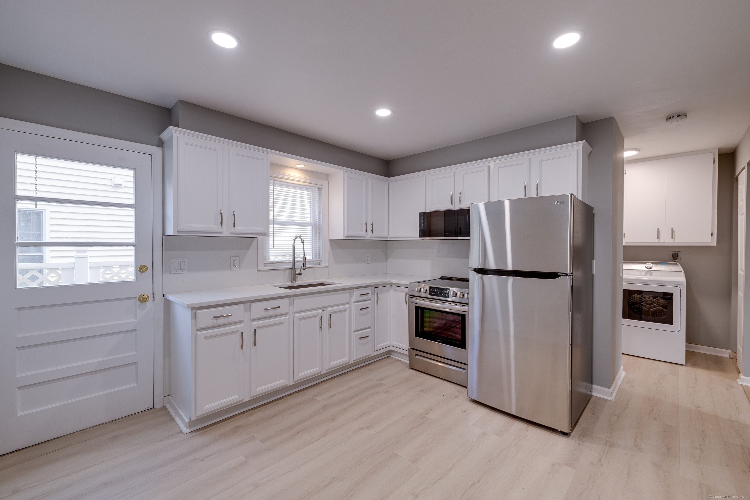 a kitchen with stainless steel appliances granite countertop a refrigerator and a stove top oven