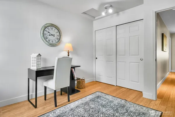 a view of a workspace room with wooden floor a table and a chair