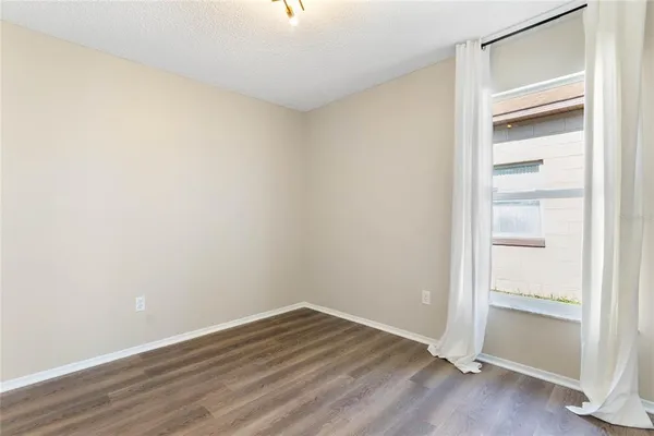 a view of an empty room with wooden floor