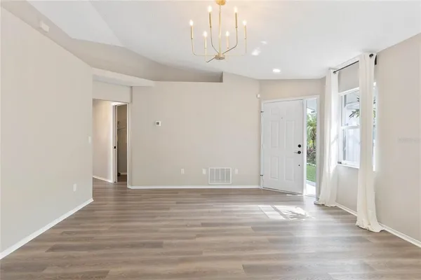 a view of an empty room with wooden floor