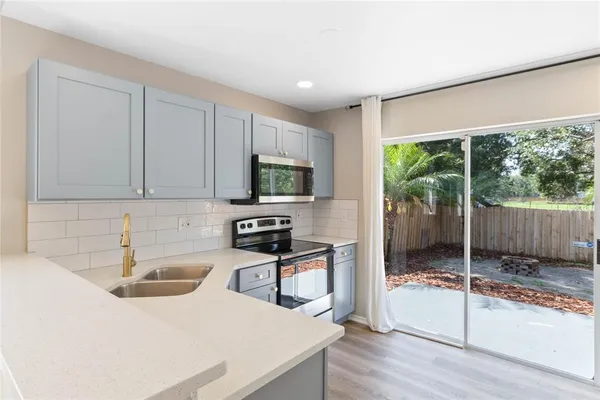 a kitchen with a sink a counter top space and a wooden floor