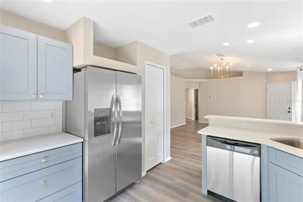 a kitchen with kitchen island a counter top space cabinets and stainless steel appliances