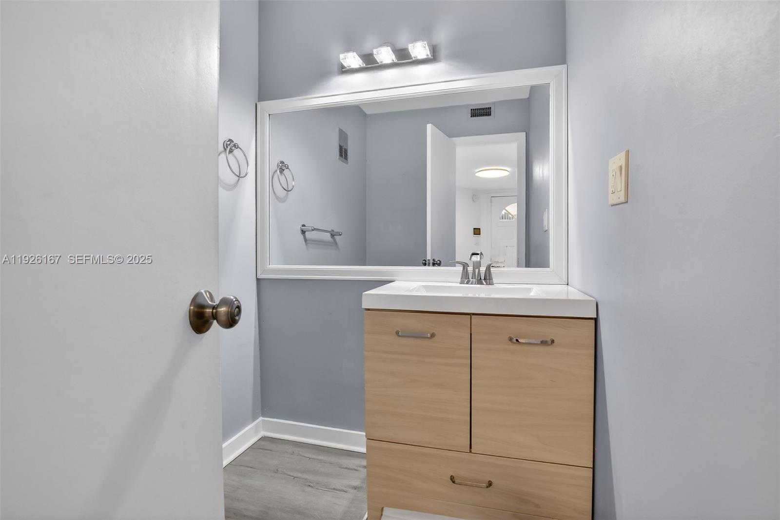 9703 North New River Canal Road, Unit 103 Plantation, FL 33324 - Photo 15 of 32 a bathroom with a sink vanity and mirror