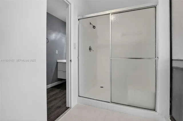 an empty room with wooden floor and ceiling fan