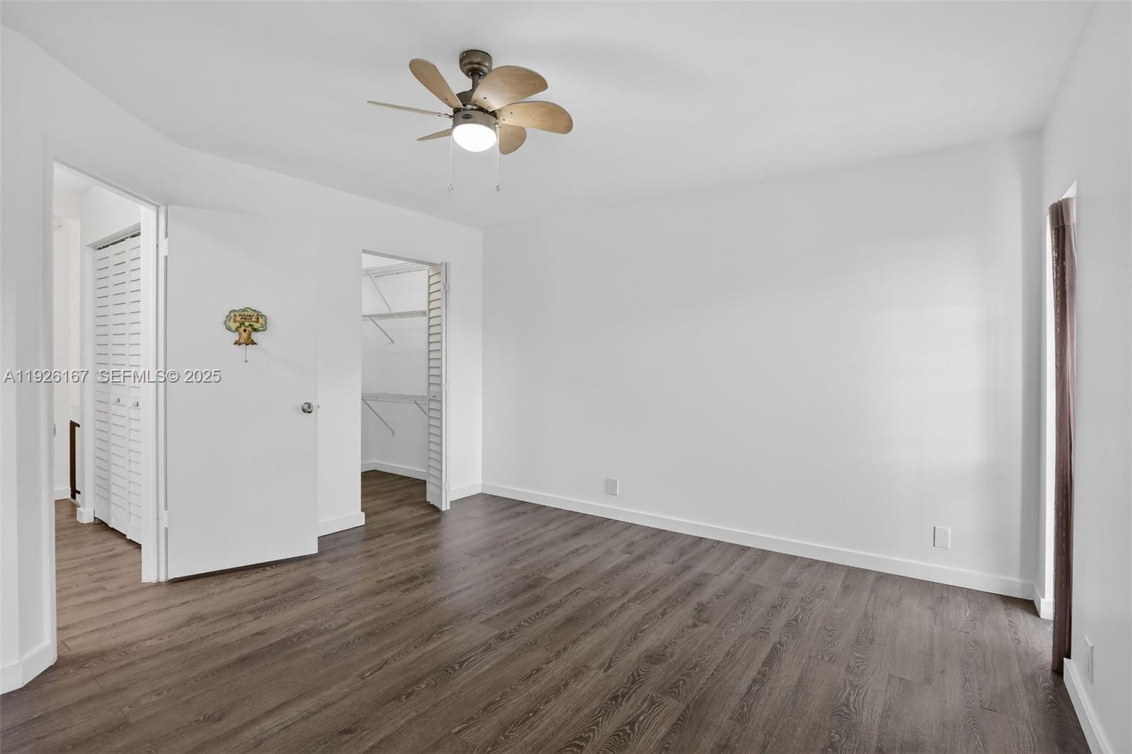 9703 North New River Canal Road, Unit 103 Plantation, FL 33324 - Photo 25 of 32 an empty room with wooden floor and ceiling fan