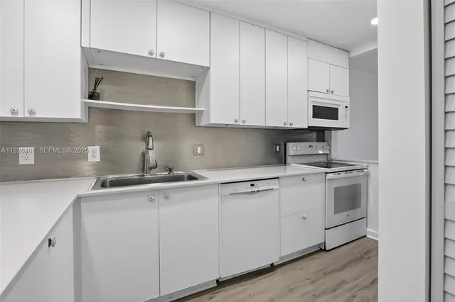 a kitchen with stainless steel appliances granite countertop white cabinets a sink and dishwasher