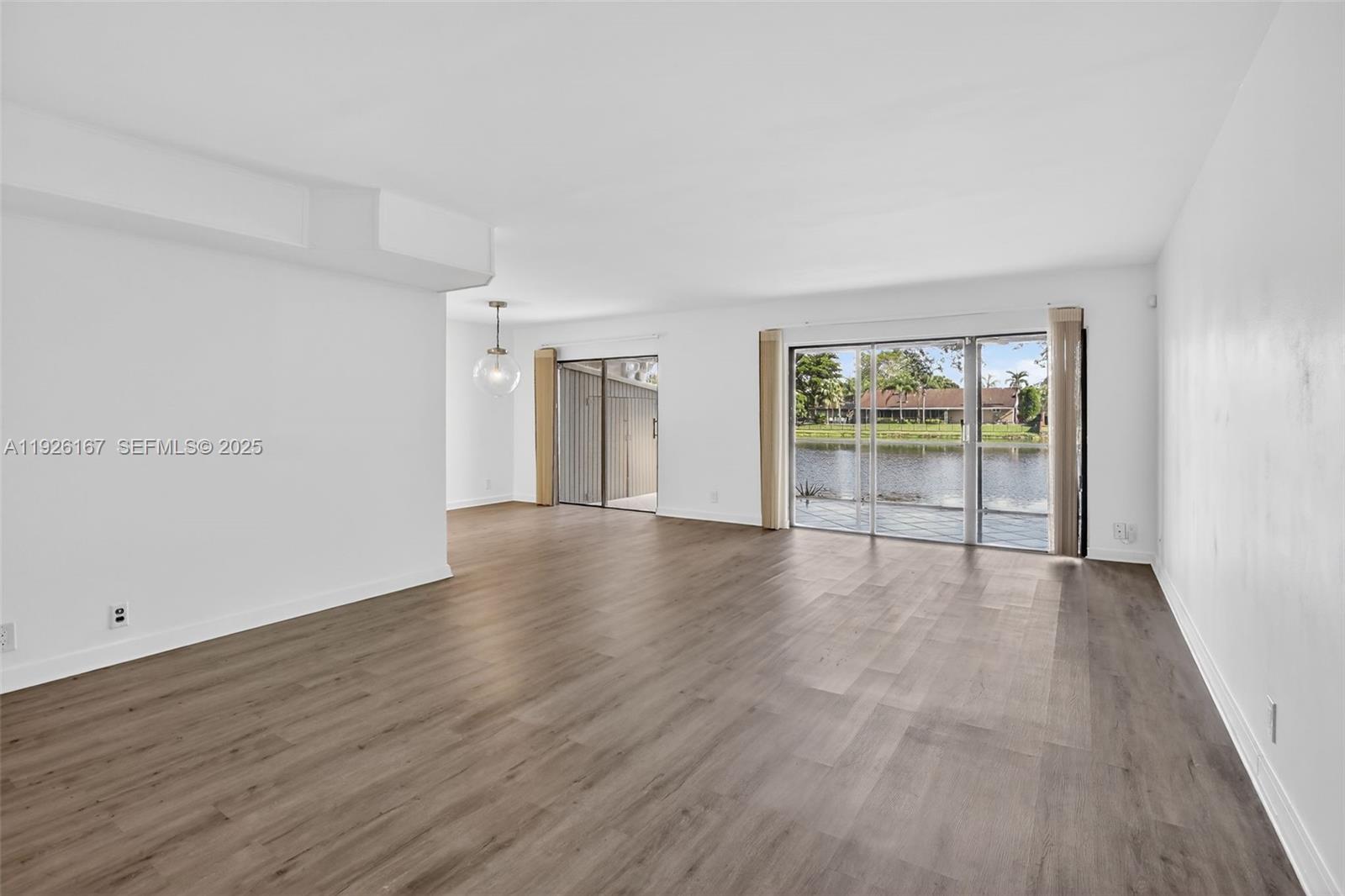 9703 North New River Canal Road, Unit 103 Plantation, FL 33324 - Photo 9 of 32 an empty room with wooden floor and windows
