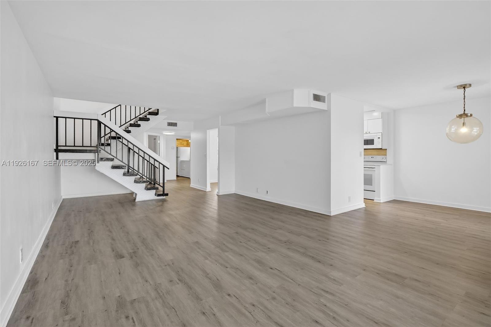 9703 North New River Canal Road, Unit 103 Plantation, FL 33324 - Photo 10 of 32 a view of an empty room with wooden floor and stairs