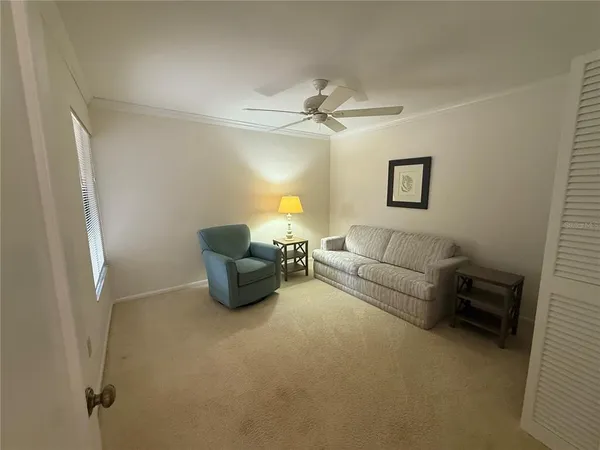 a living room with furniture and a ceiling fan