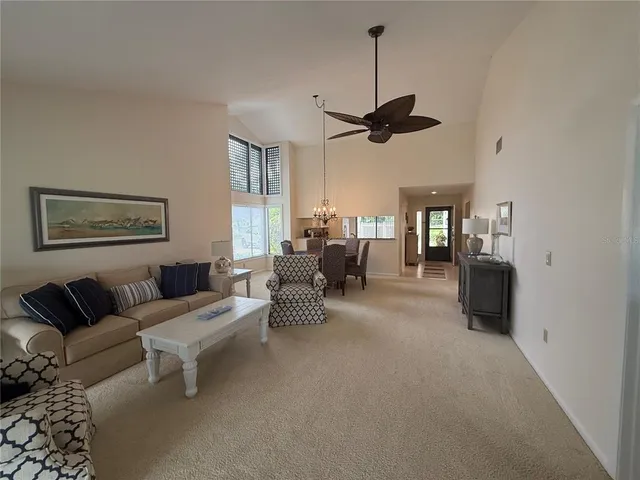 a living room with furniture a ceiling fan and a rug
