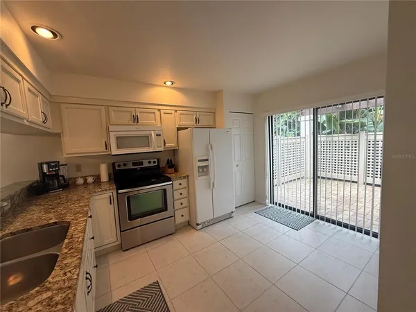 a kitchen with stainless steel appliances granite countertop a stove a sink and a refrigerator