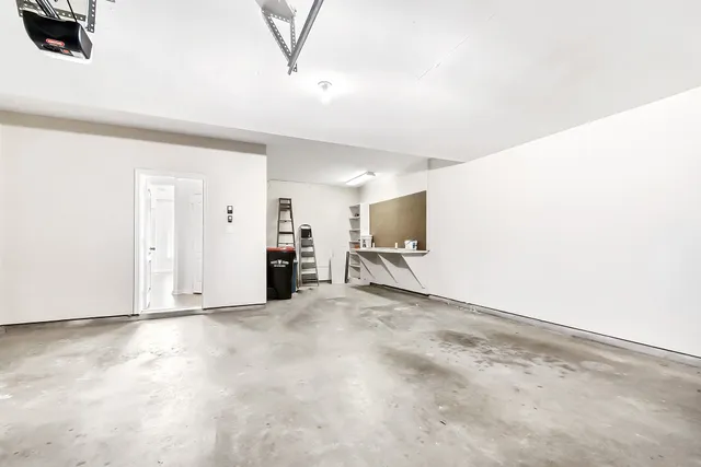 an empty room with chandelier fan and windows
