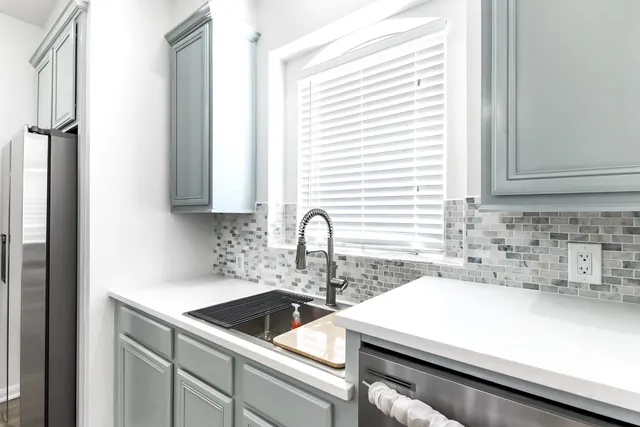 a kitchen with stainless steel appliances a sink a counter top space and a center island