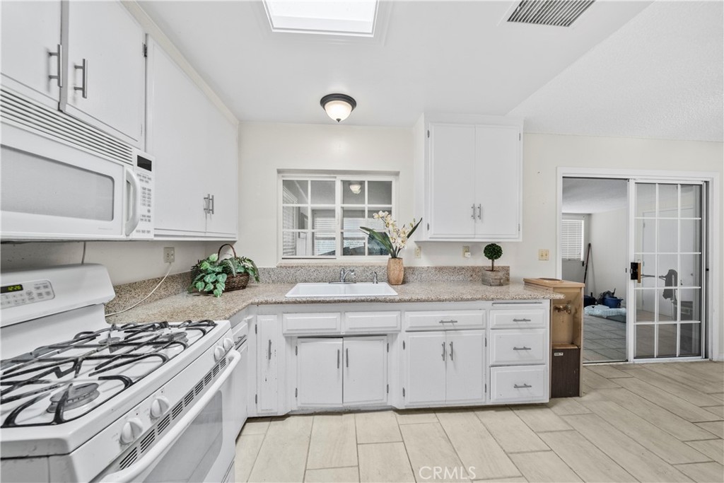 820 South Alessandro Street Hemet, CA 92543 - Photo 4 of 37 a kitchen with a stove a sink and a refrigerator