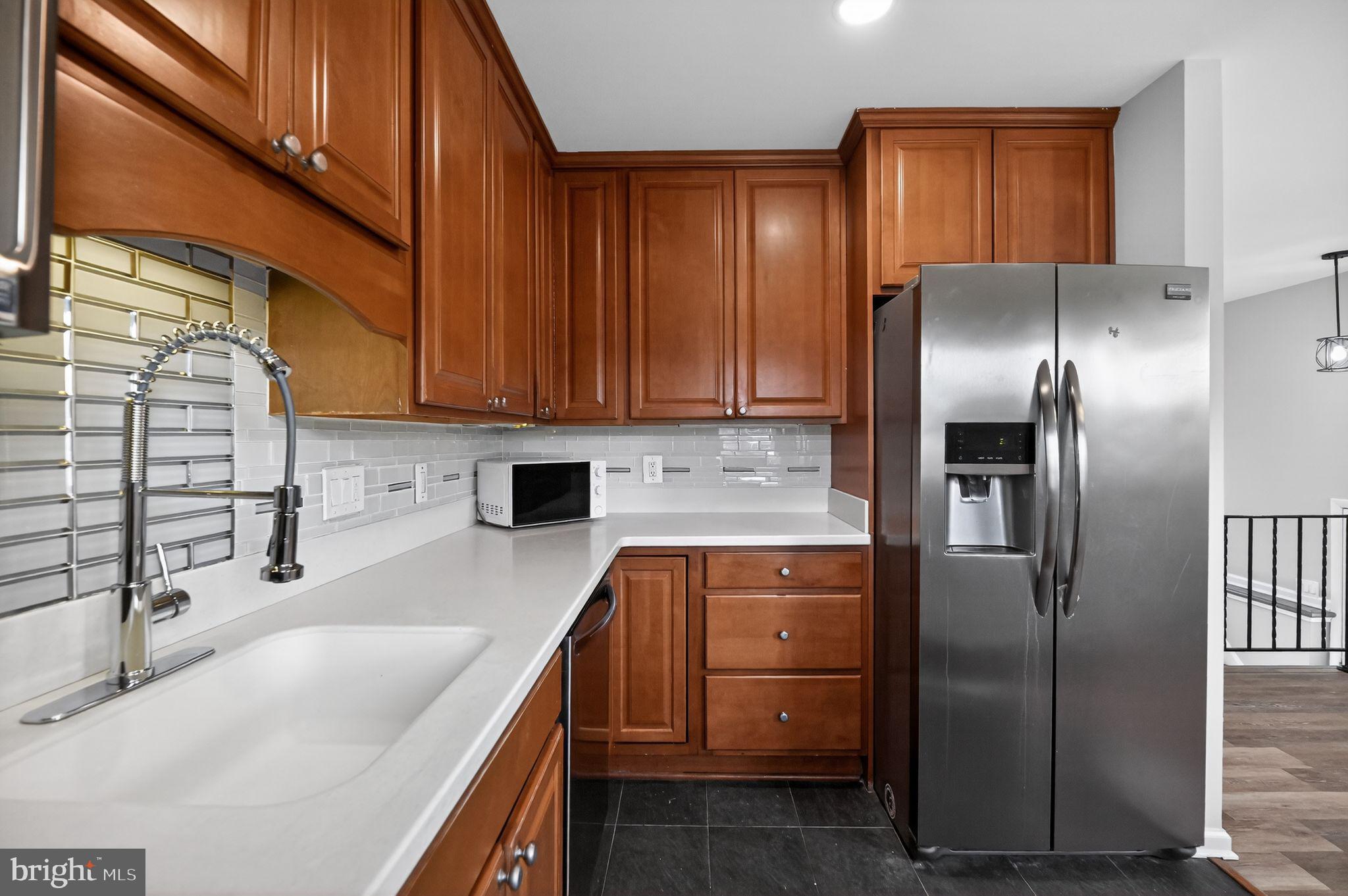 8012 Frye Road Alexandria, VA 22309 - Photo 17 of 40 a kitchen with stainless steel appliances granite countertop a refrigerator a sink and white cabinets