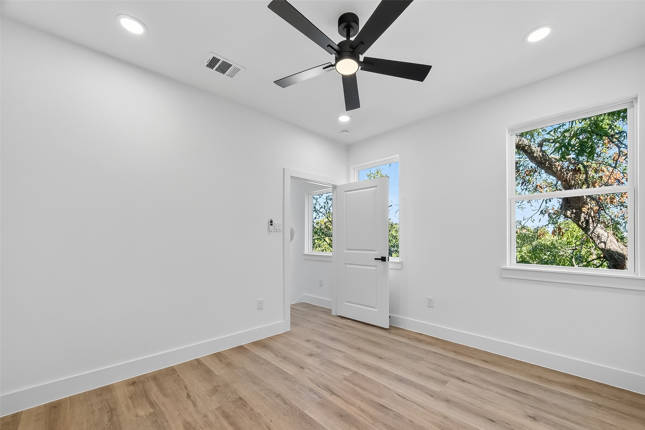 3315 Nettleton Street Houston, TX 77004 - Photo 24 of 38 an empty room with wooden floor ceiling fan and windows