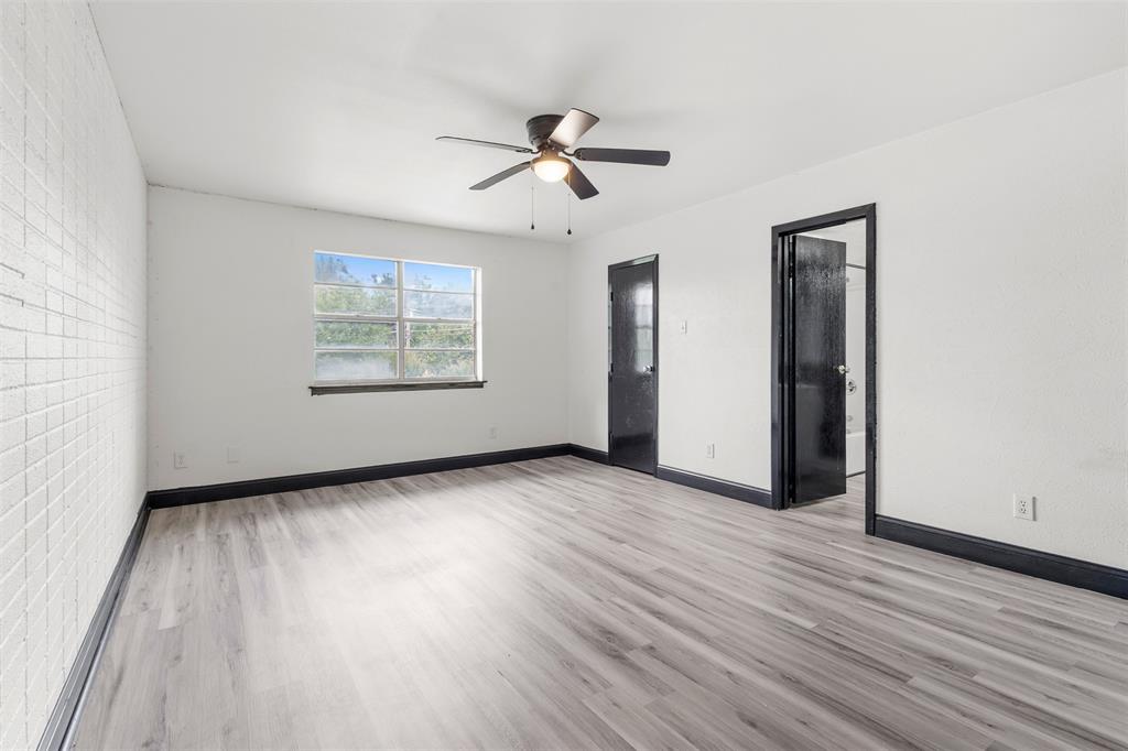 2802 Spring Valley Drive Bedford, TX 76021 - Photo 15 of 24 an empty room with wooden floor chandelier fan and windows