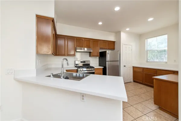 a kitchen with stainless steel appliances a refrigerator sink stove microwave and cabinets